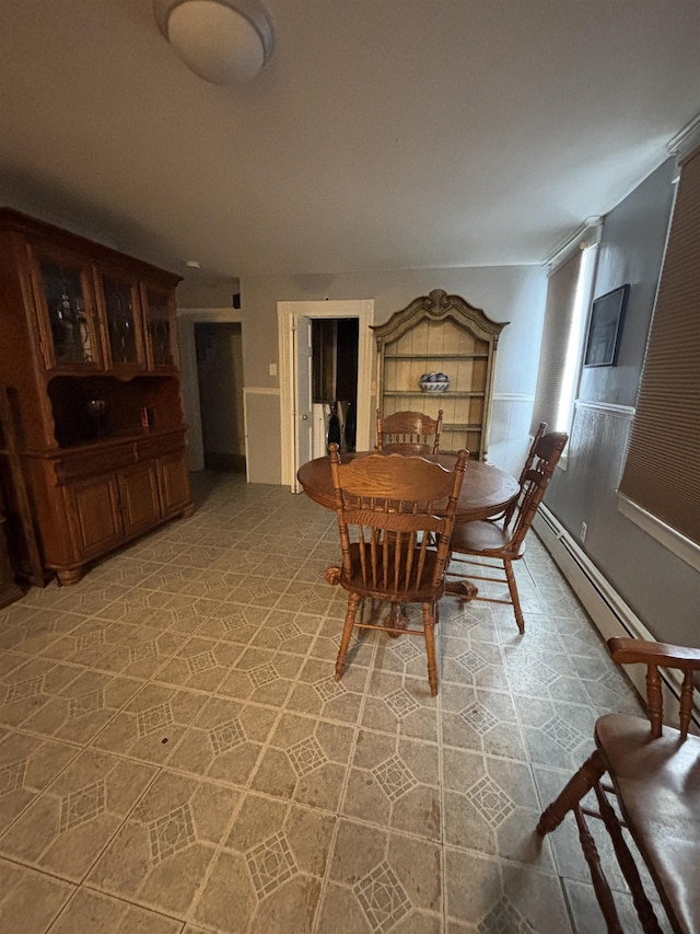 dining area with a baseboard heating unit and light floors