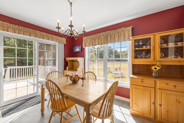 dining room featuring an inviting chandelier, light tile patterned floors, and baseboards