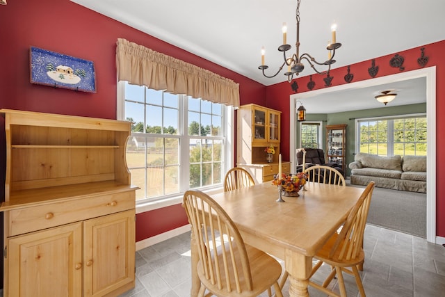 dining room featuring plenty of natural light, an inviting chandelier, and baseboards