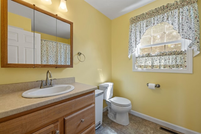 bathroom featuring vanity, baseboards, visible vents, tile patterned flooring, and toilet