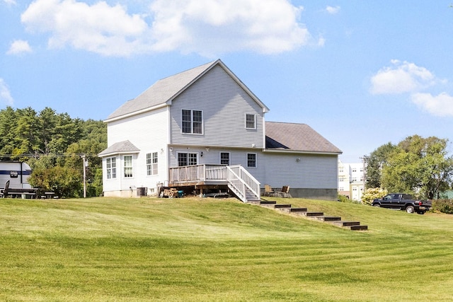 rear view of property featuring a lawn and a wooden deck