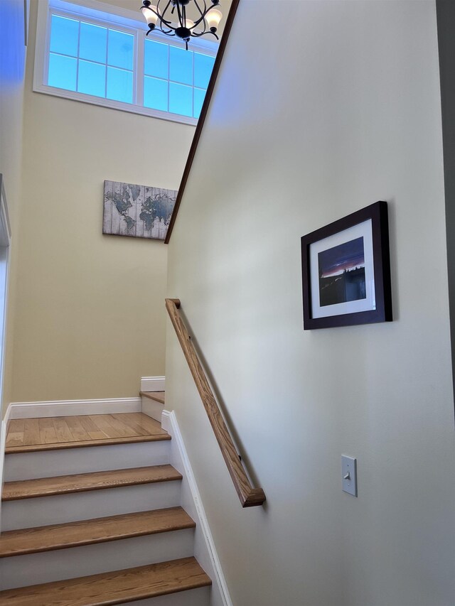 stairs with baseboards and a notable chandelier