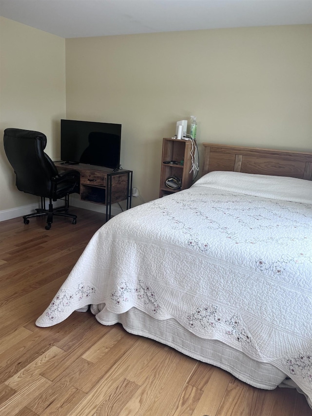 bedroom with baseboards and wood finished floors