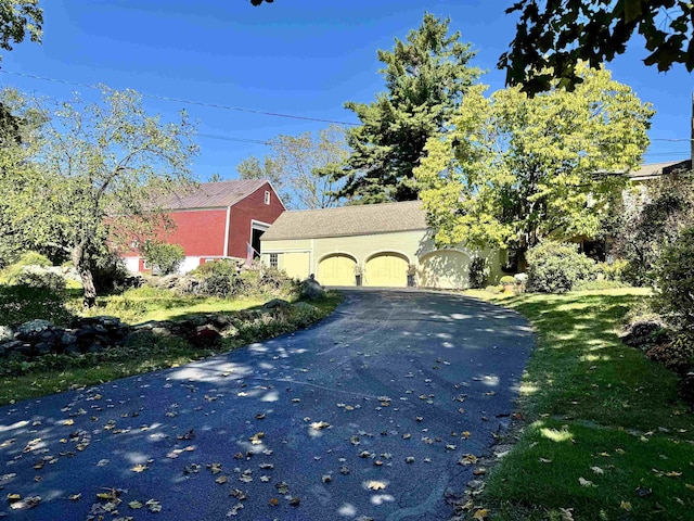 exterior space with aphalt driveway and an attached garage