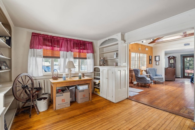 office area with a baseboard heating unit, wood-type flooring, and crown molding