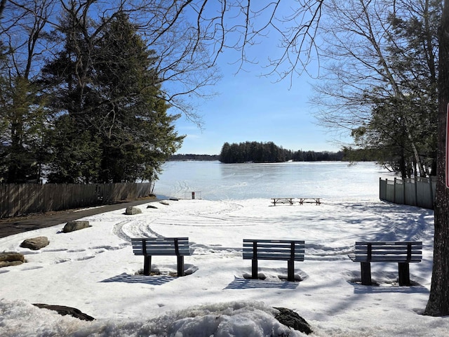 view of property's community with fence and a water view