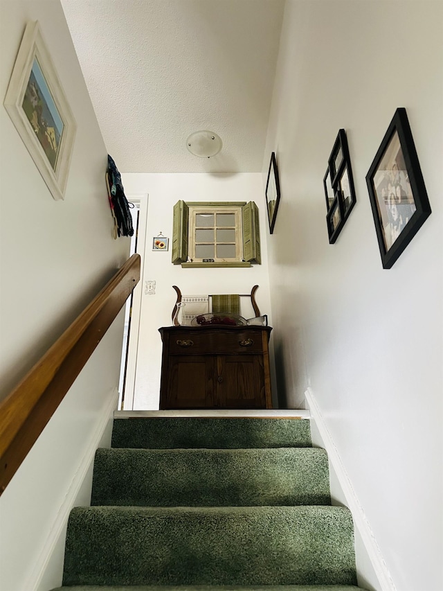 stairs with a textured ceiling and baseboards