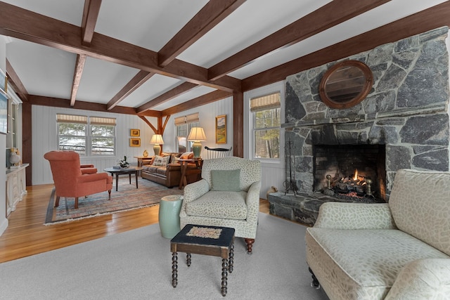 living room with wood finished floors, a fireplace, and beam ceiling