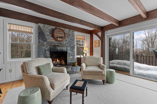 sitting room with wood finished floors, a fireplace, and beam ceiling