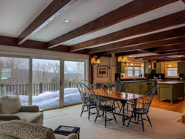 dining space featuring an inviting chandelier and beamed ceiling