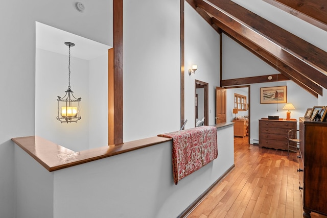 interior space with a baseboard heating unit, beam ceiling, high vaulted ceiling, and light wood-style flooring