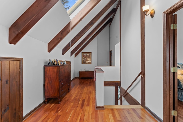 bonus room with beam ceiling, a skylight, baseboards, and wood-type flooring