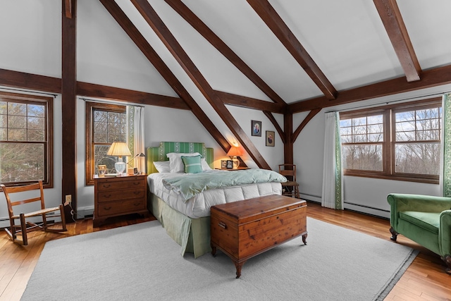 bedroom with beam ceiling, a baseboard heating unit, and wood finished floors