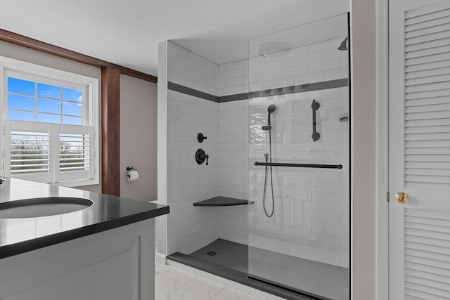 bathroom with a tile shower, tile patterned floors, and vanity