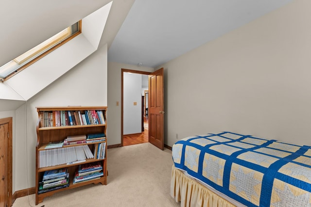 carpeted bedroom with a skylight and baseboards