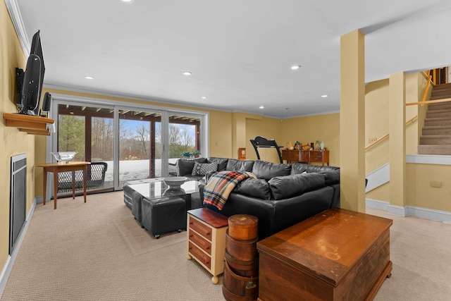 living area with crown molding, baseboards, light colored carpet, stairs, and a fireplace