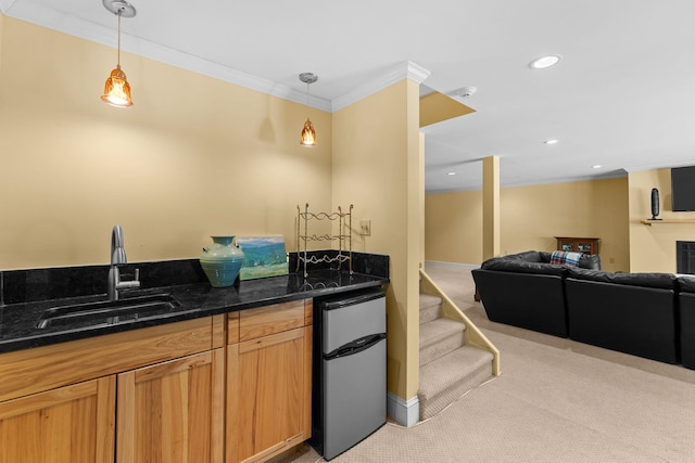 kitchen with light carpet, hanging light fixtures, crown molding, and a sink