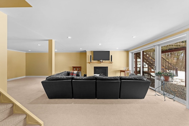 living area with light carpet, ornamental molding, recessed lighting, stairway, and a fireplace