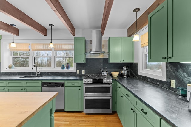 kitchen featuring a sink, plenty of natural light, stainless steel appliances, wall chimney exhaust hood, and green cabinets