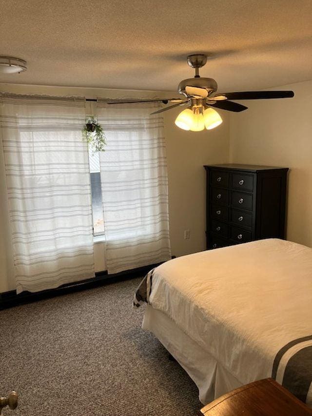 bedroom with a textured ceiling, ceiling fan, and carpet flooring