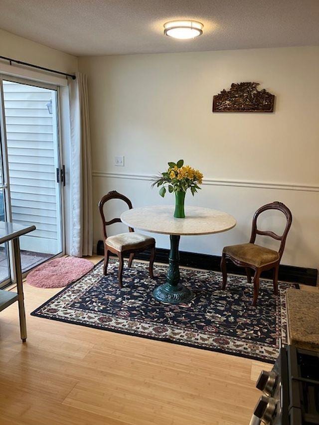 dining space featuring a textured ceiling and wood finished floors