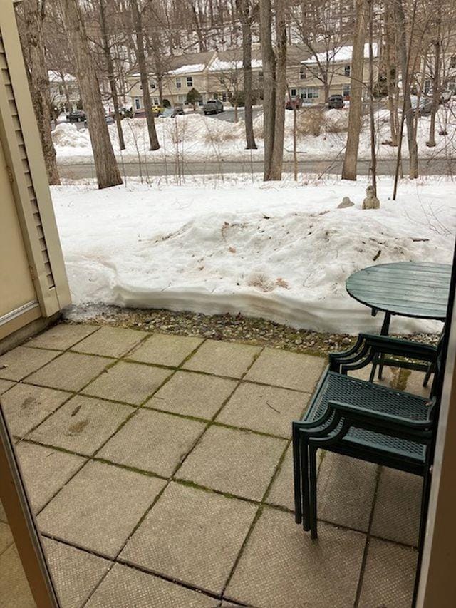 snow covered patio with a residential view