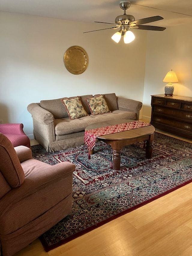 living room with wood finished floors and ceiling fan