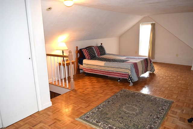 bedroom with a textured ceiling and vaulted ceiling