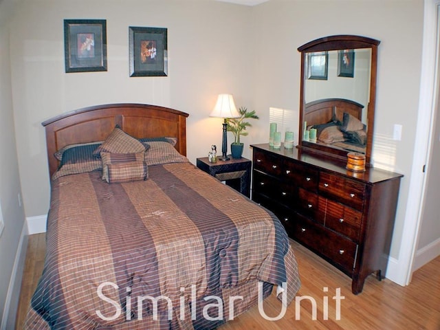 bedroom featuring baseboards and wood finished floors