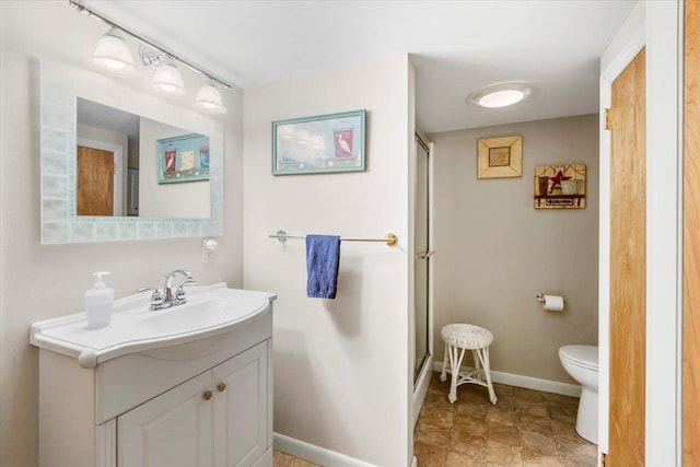 bathroom with a shower with door, baseboards, toilet, and vanity