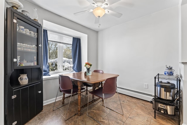 dining room featuring a baseboard heating unit, baseboards, and ceiling fan