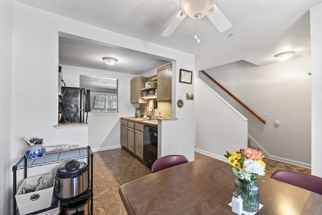 dining room featuring stone tile flooring, a ceiling fan, stairs, and baseboards