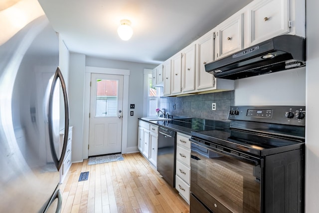 kitchen with black appliances, white cabinets, under cabinet range hood, and a sink