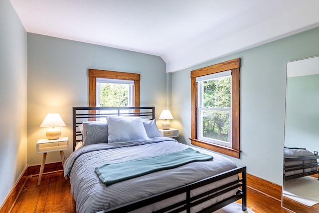 bedroom featuring vaulted ceiling, wood finished floors, and baseboards