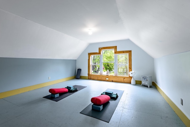 exercise room with baseboards and lofted ceiling