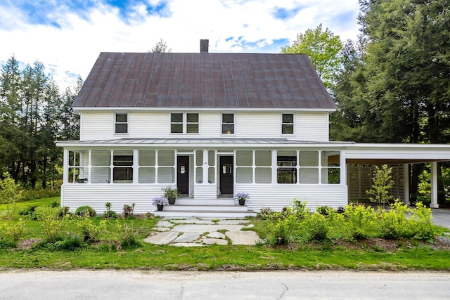 view of front of home with covered porch, a chimney, a standing seam roof, and metal roof