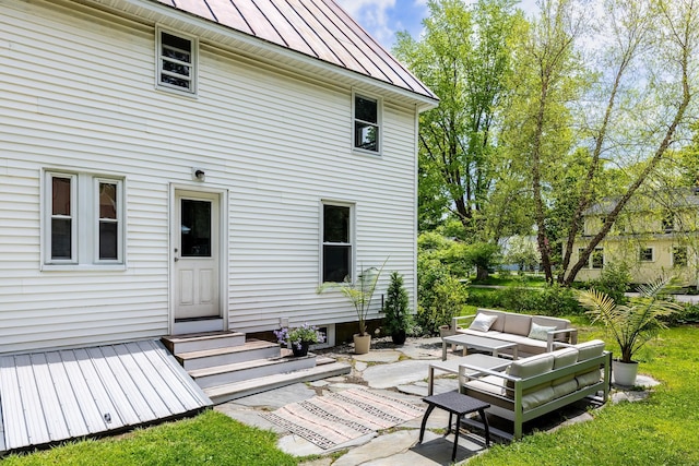 back of house with an outdoor living space, entry steps, a patio, metal roof, and a standing seam roof