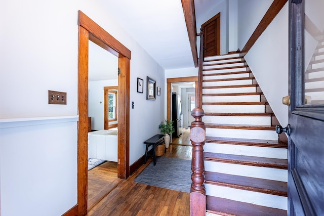 stairway with wood finished floors and baseboards