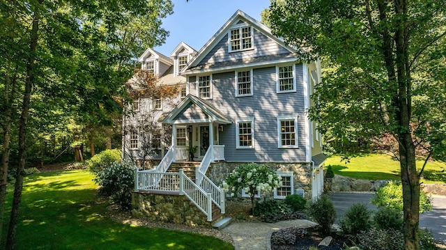 view of front of house with stairs and a front yard