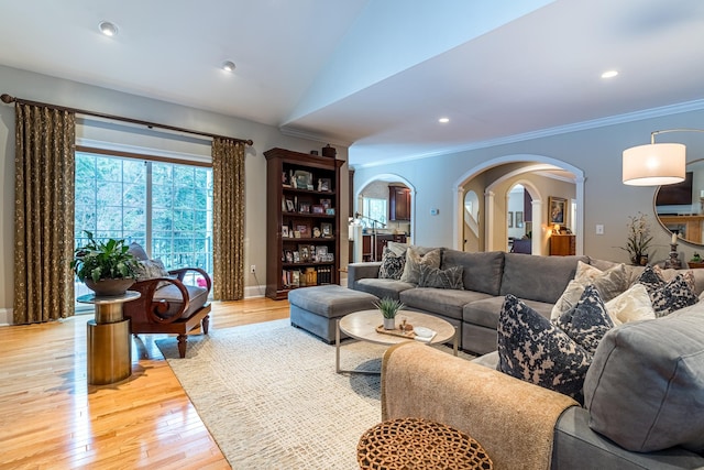 living room with light wood finished floors, crown molding, vaulted ceiling, recessed lighting, and arched walkways