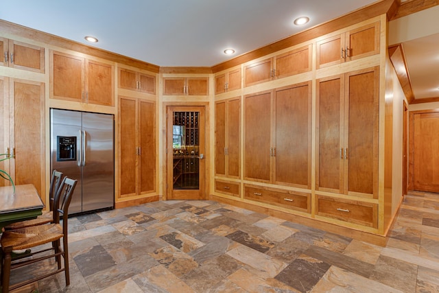 kitchen with recessed lighting, stainless steel fridge with ice dispenser, and stone finish floor