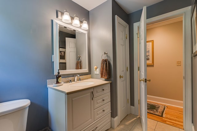 bathroom featuring vanity, tile patterned floors, toilet, and baseboards