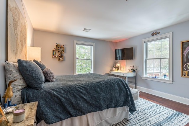 bedroom featuring dark wood finished floors, baseboards, and visible vents