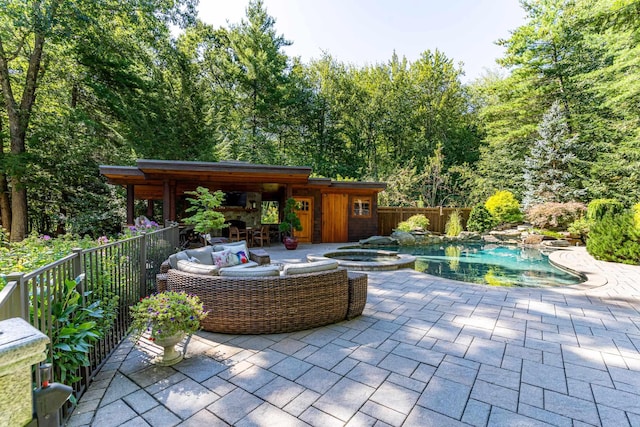 view of patio featuring a pool with connected hot tub and fence