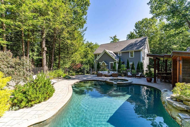 view of swimming pool with a patio area, an outdoor living space, a pool with connected hot tub, and fence