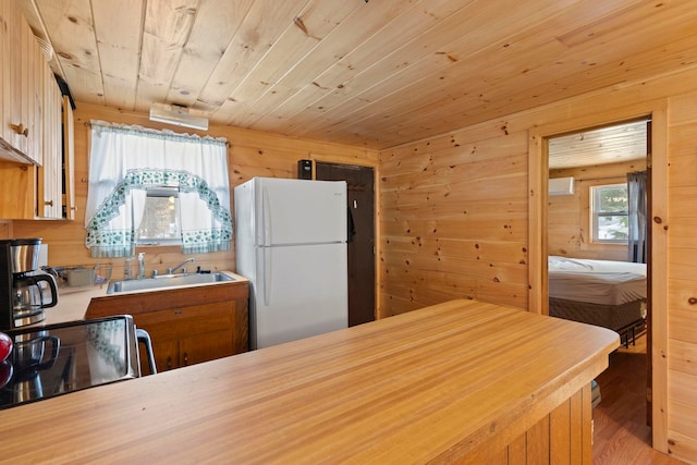 kitchen featuring wood ceiling, freestanding refrigerator, light countertops, and a sink