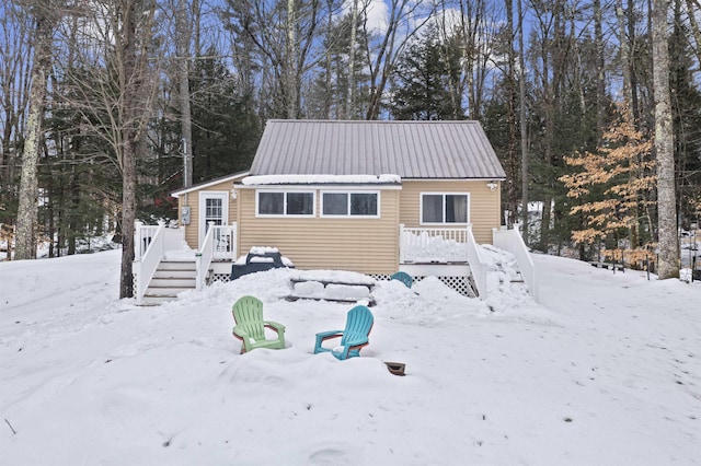 exterior space with a wooden deck and metal roof