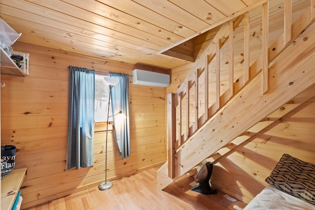 interior space featuring wood ceiling, wooden walls, an AC wall unit, and wood finished floors