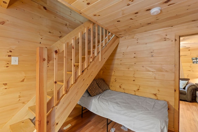 bedroom with a sauna, wood finished floors, wood walls, and wooden ceiling