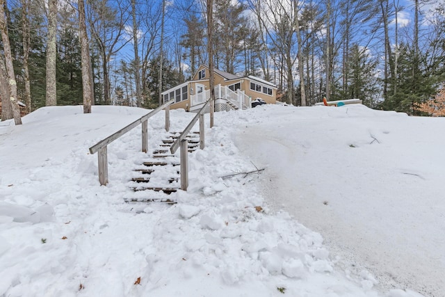 snowy yard with a deck and a garage